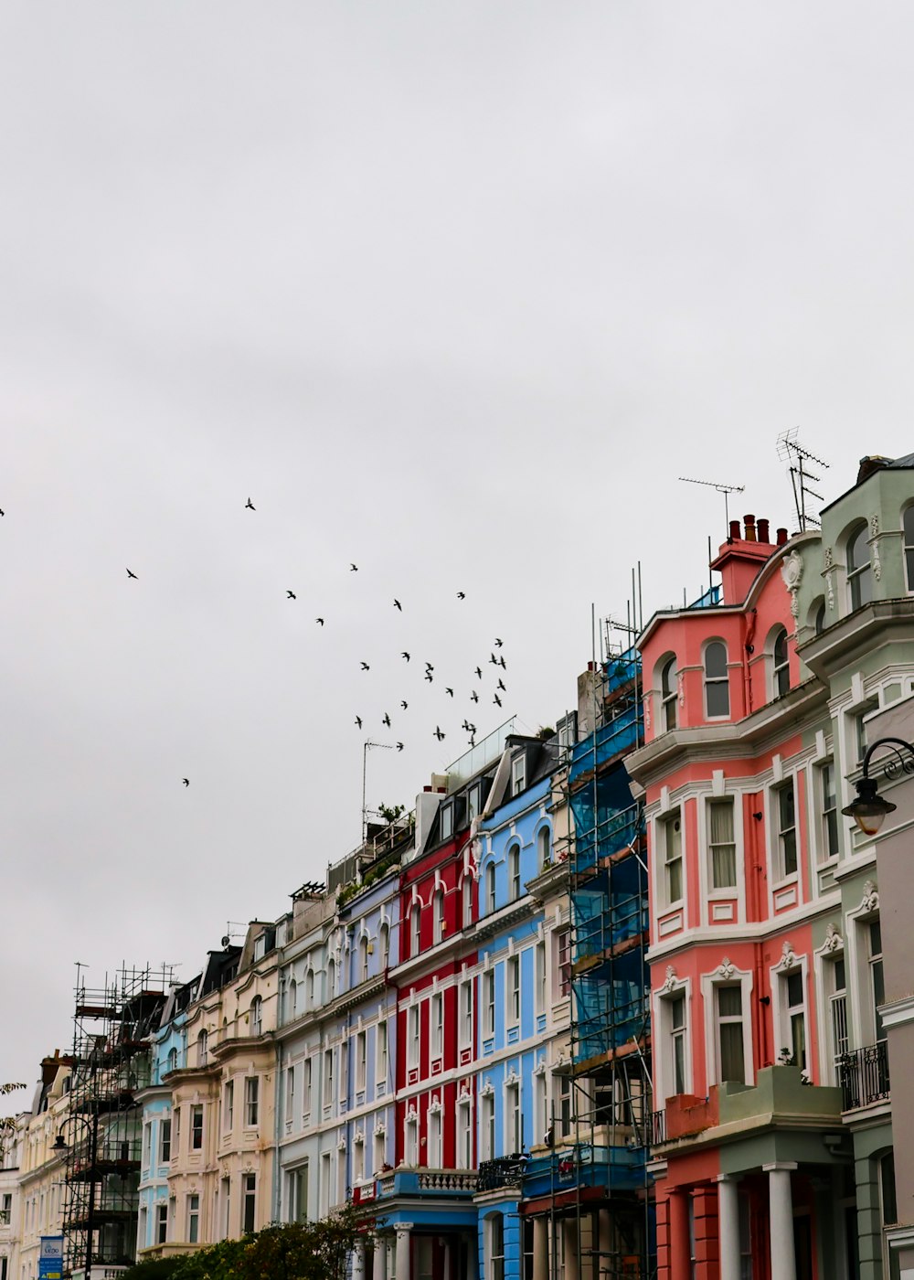 a row of multi - colored buildings with scaffolding on them