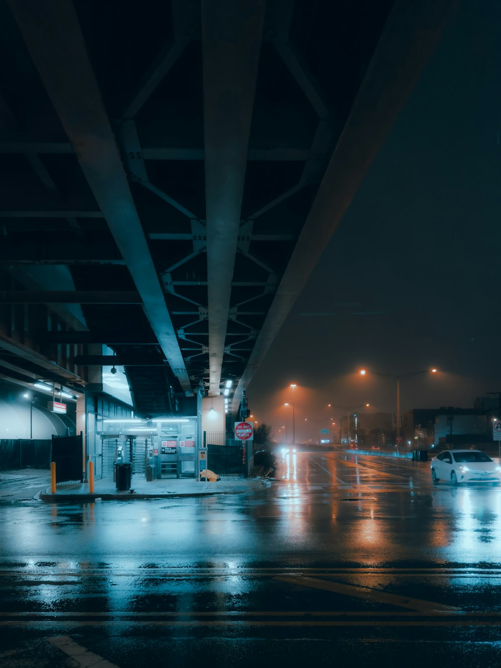 a city street at night with cars driving on it