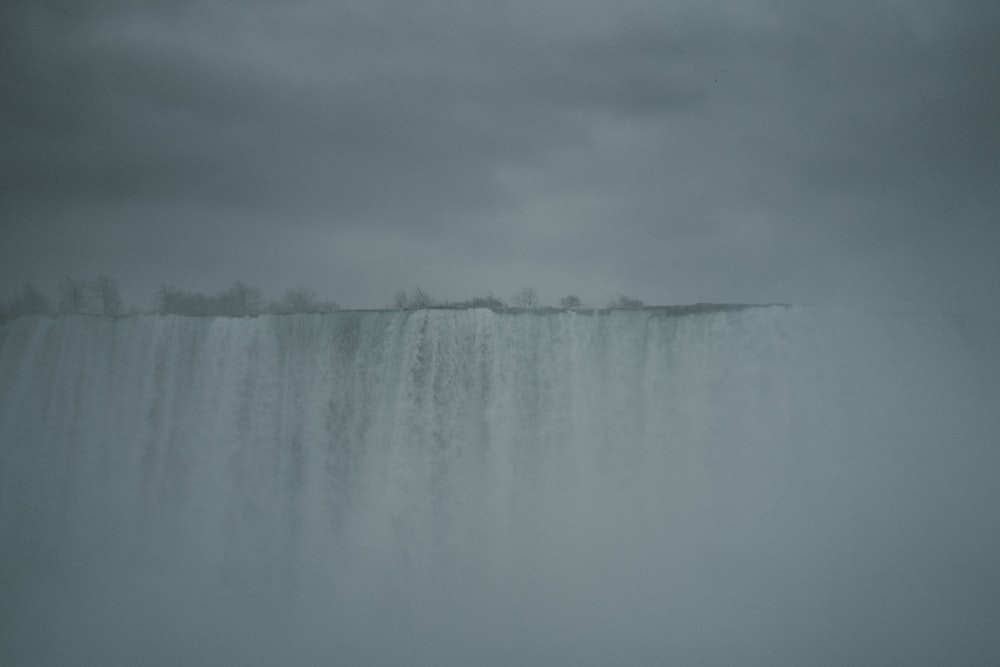 a large waterfall in the middle of a body of water