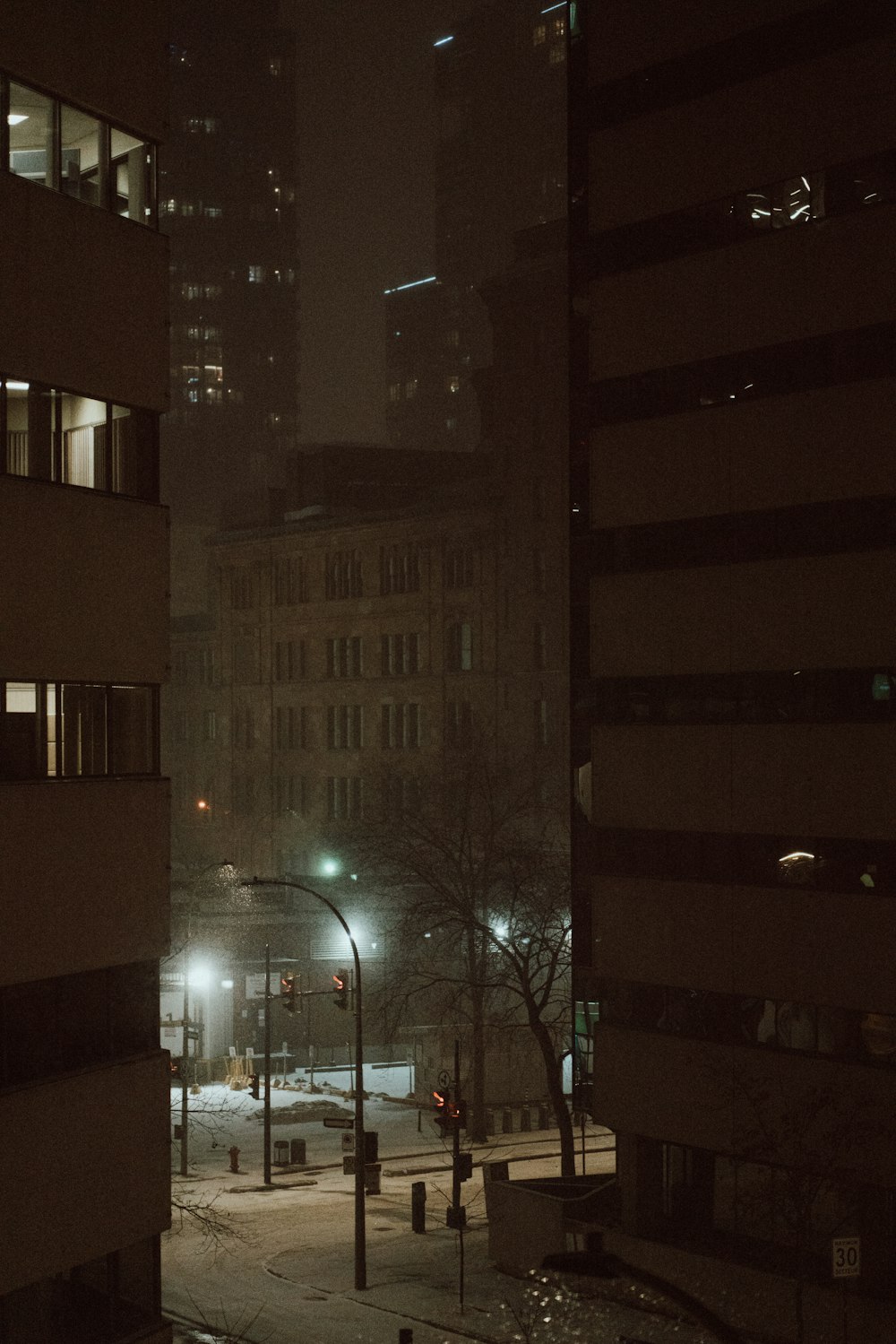 une rue de la ville la nuit avec des bâtiments éclairés