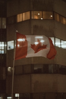 a canadian flag flying in front of a building