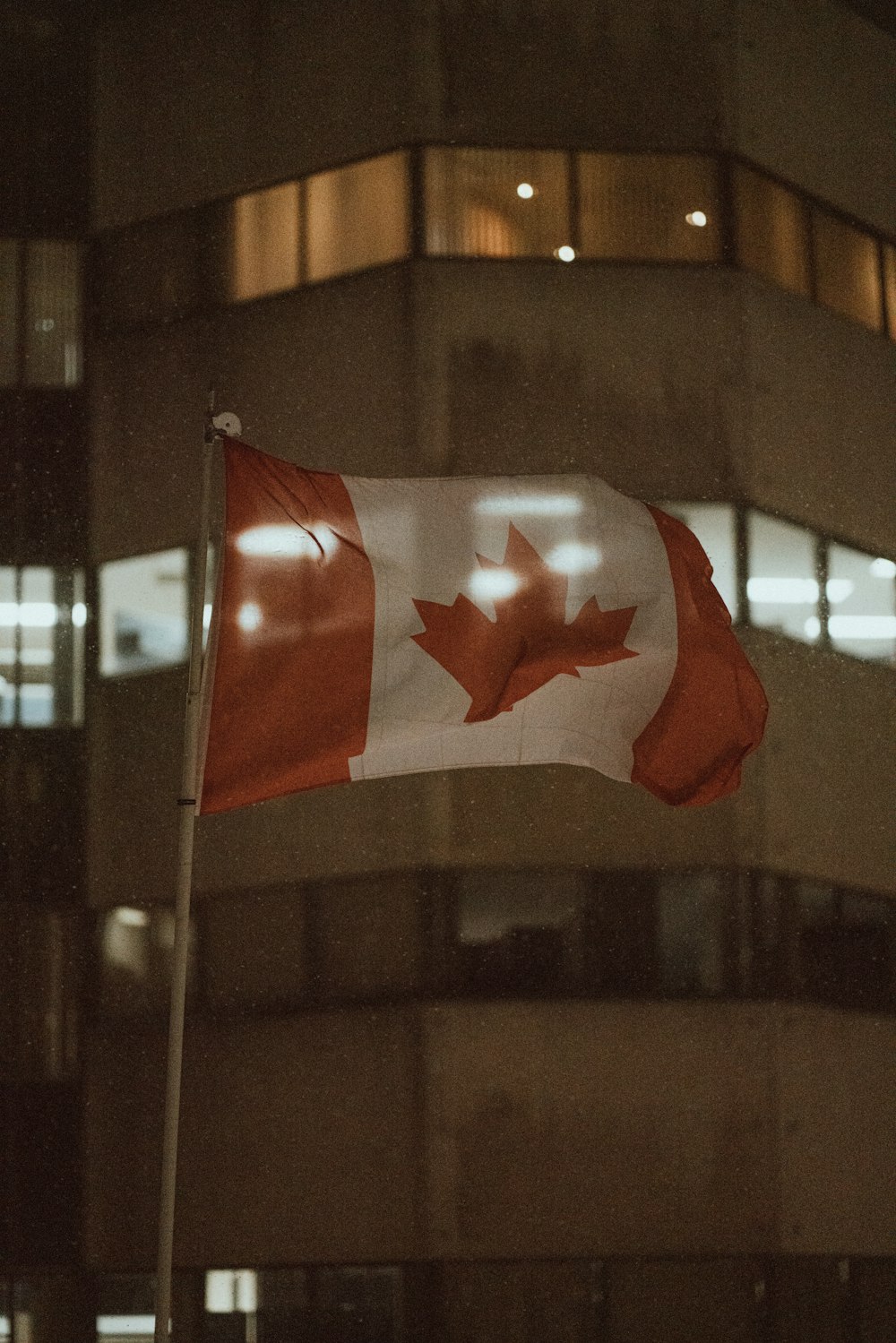 a canadian flag flying in front of a building