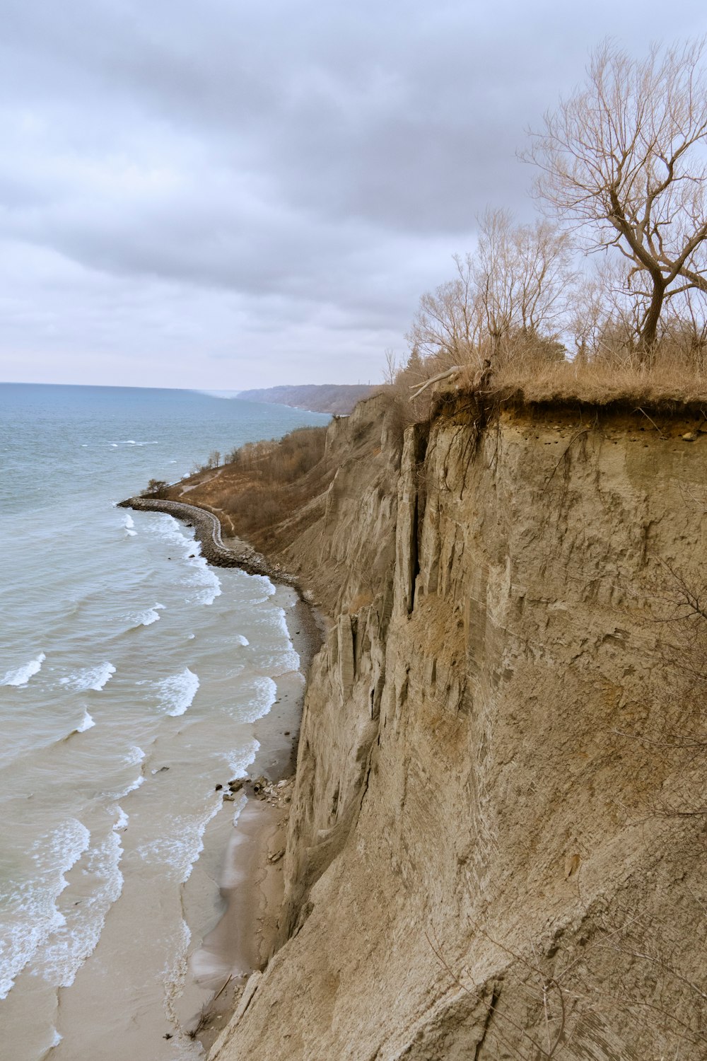 a cliff overlooking the ocean on a cloudy day