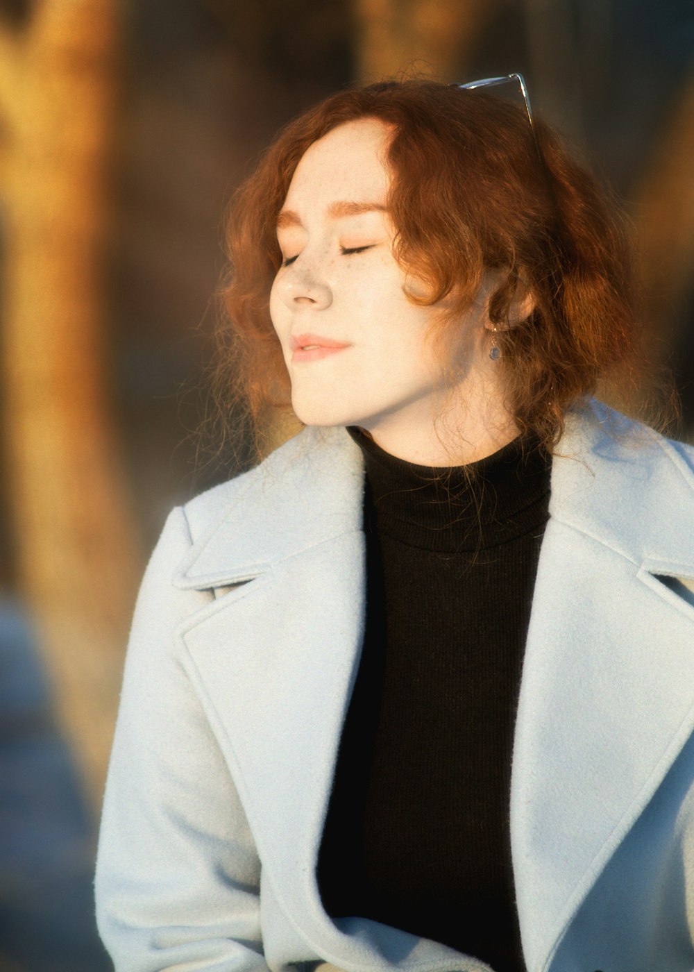 a woman with red hair wearing a blue coat