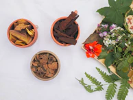 three small bowls filled with different types of flowers