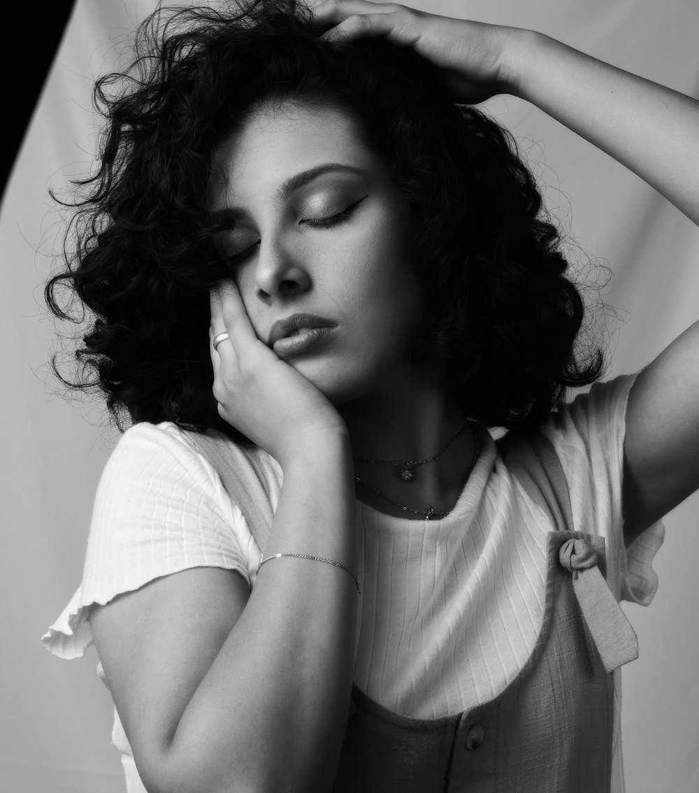 a black and white photo of a woman with her hands on her head