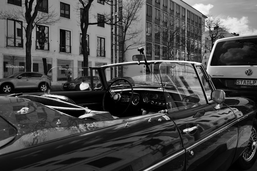 a black and white photo of a car and a bus