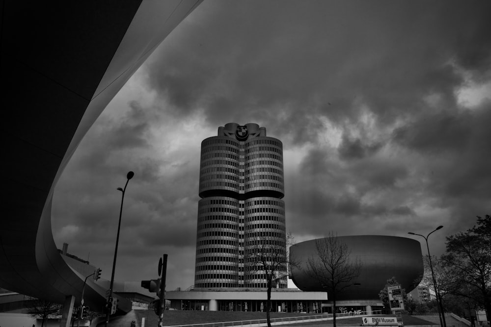 a tall building sitting next to a tall building under a cloudy sky