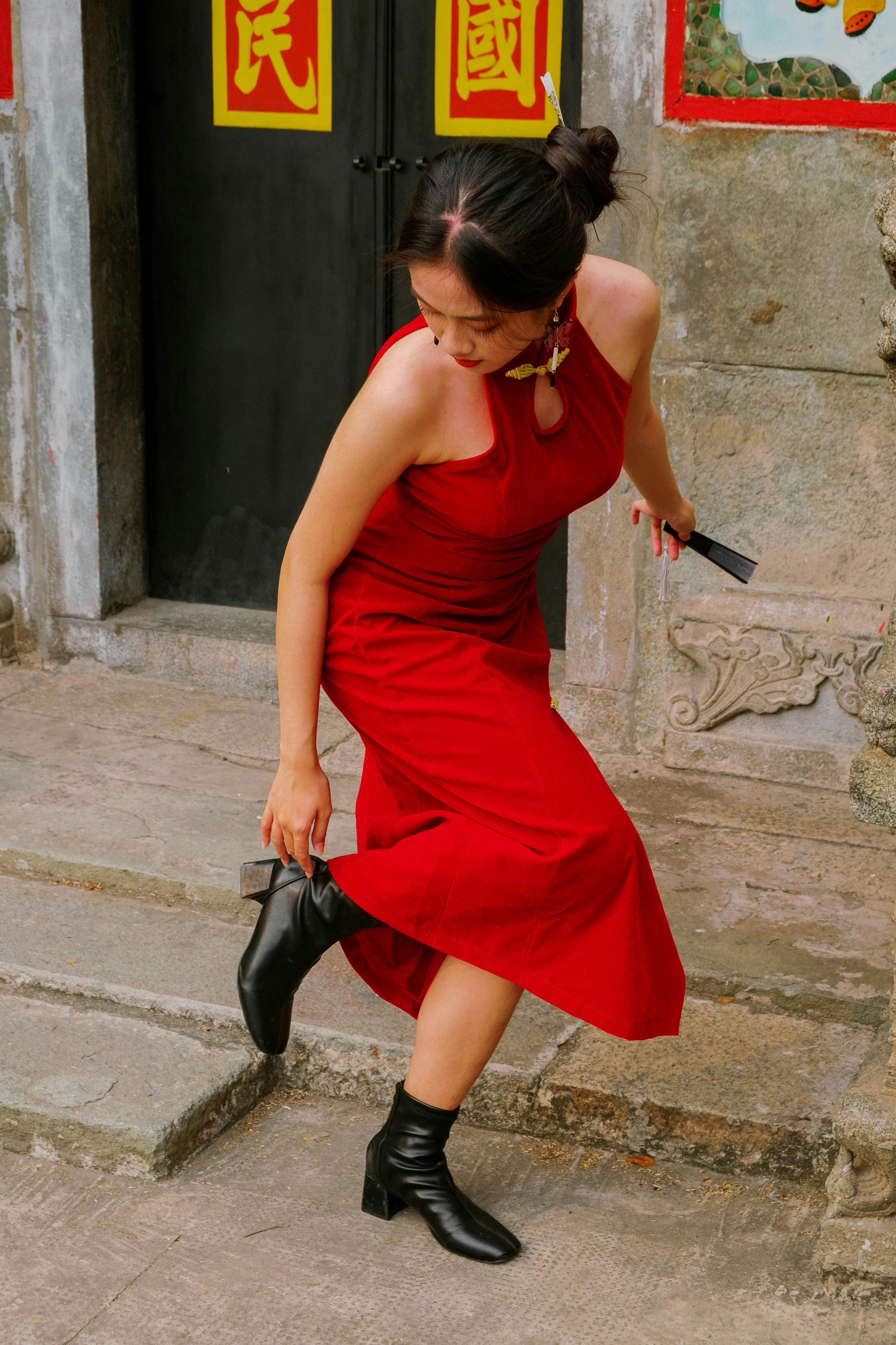 a woman in a red dress holding a black umbrella