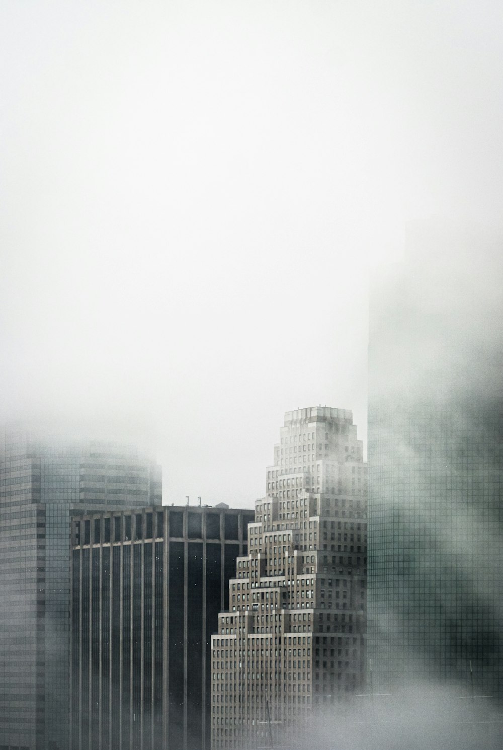 a very tall building in the middle of a foggy city