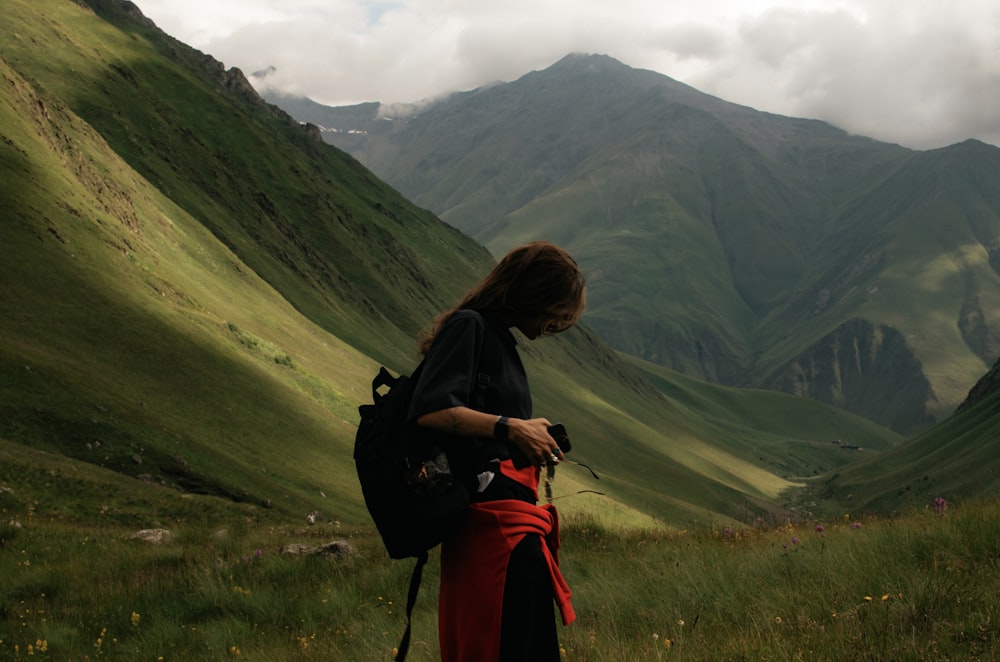 a woman with a backpack looking at her cell phone