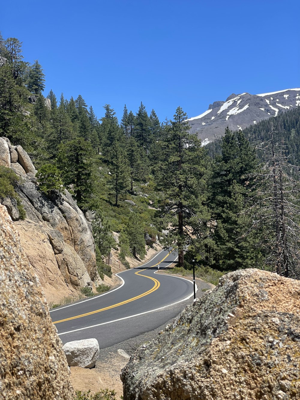 a winding road with a mountain in the background