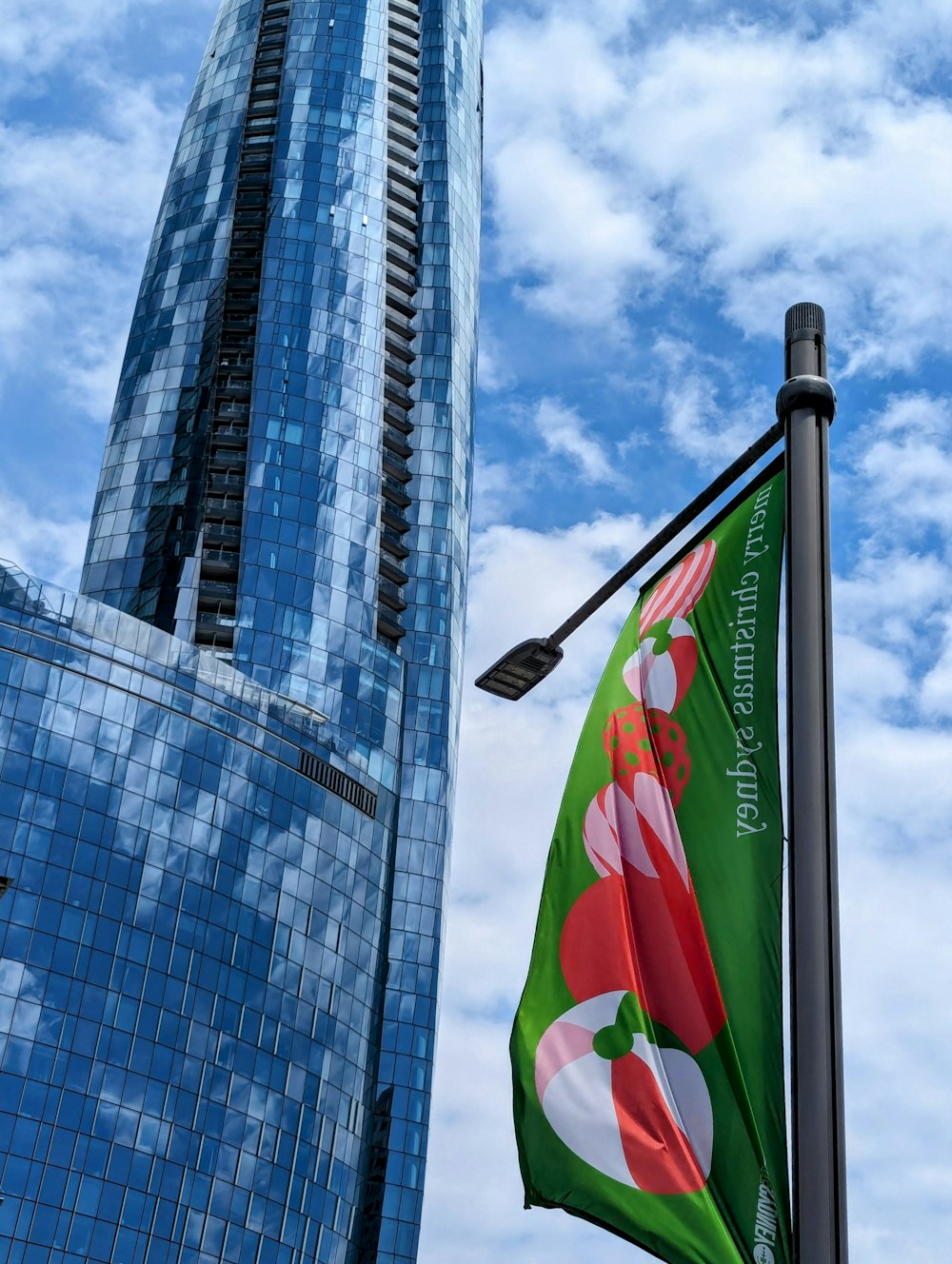 a green and red flag flying next to a tall building