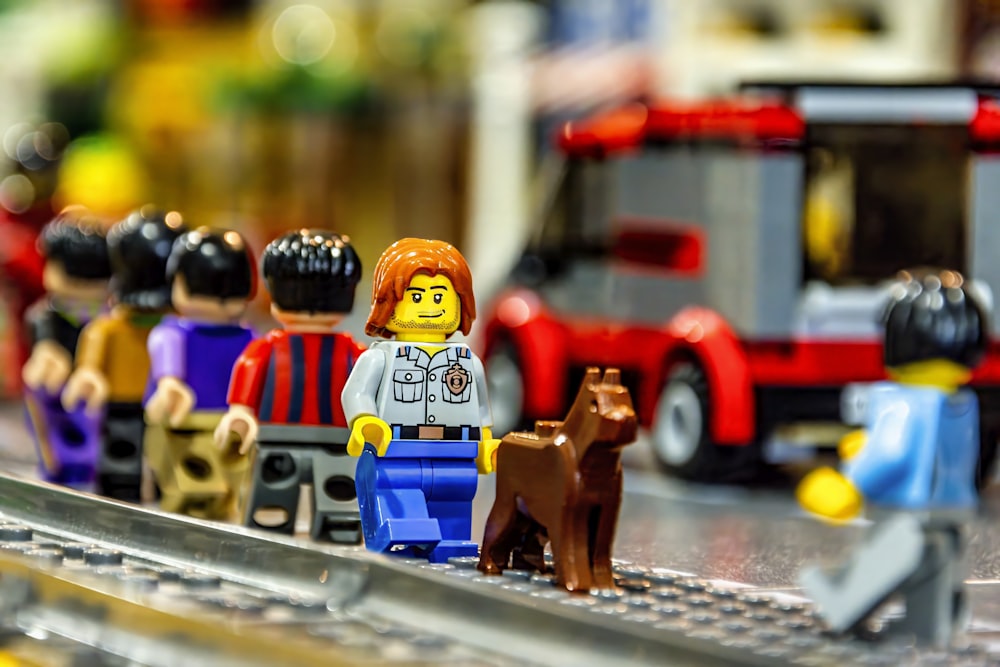 a group of lego people standing on a train track
