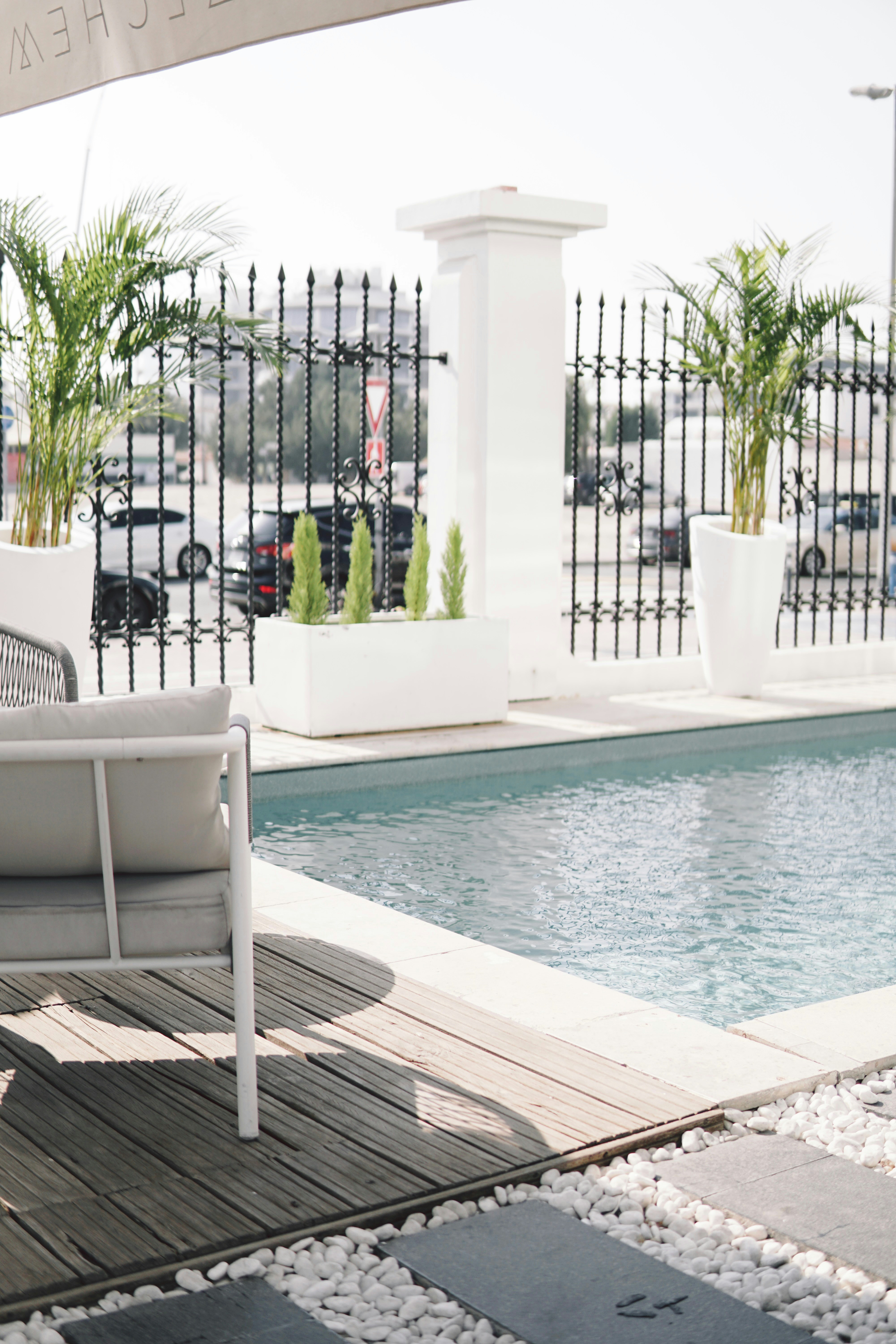 a white bench sitting next to a swimming pool
