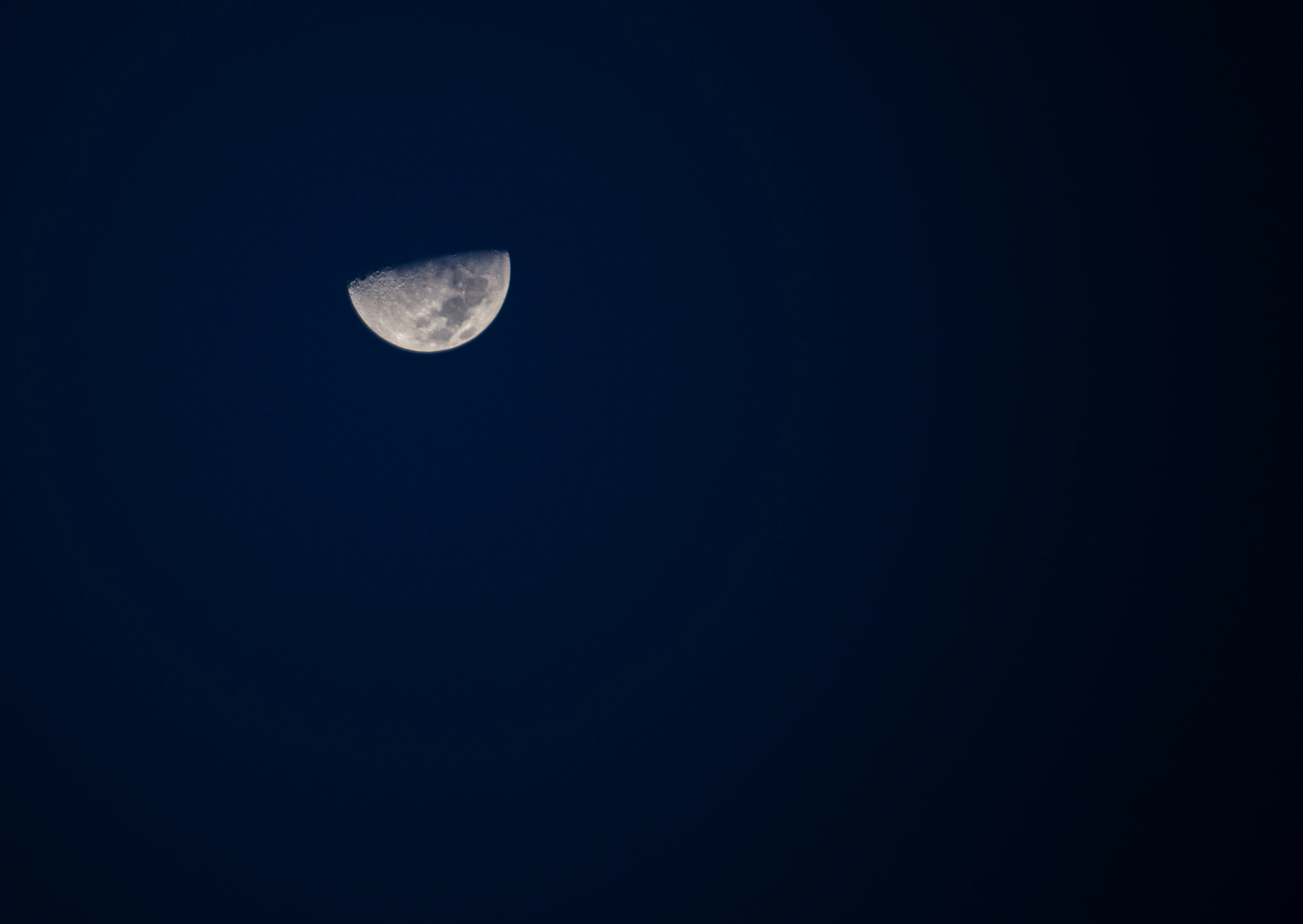 Ein Halbmond ist am dunklen Himmel zu sehen