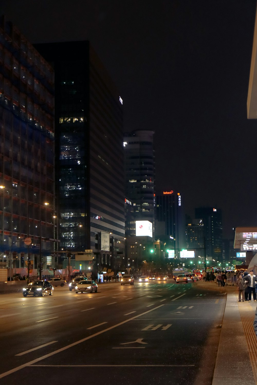 a city street at night with cars and buildings