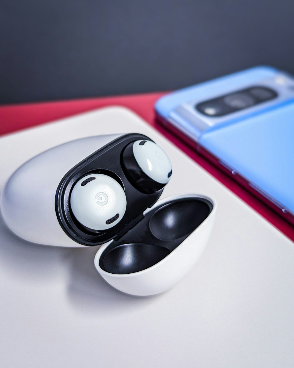 a pair of black and white earbuds sitting on top of a white table