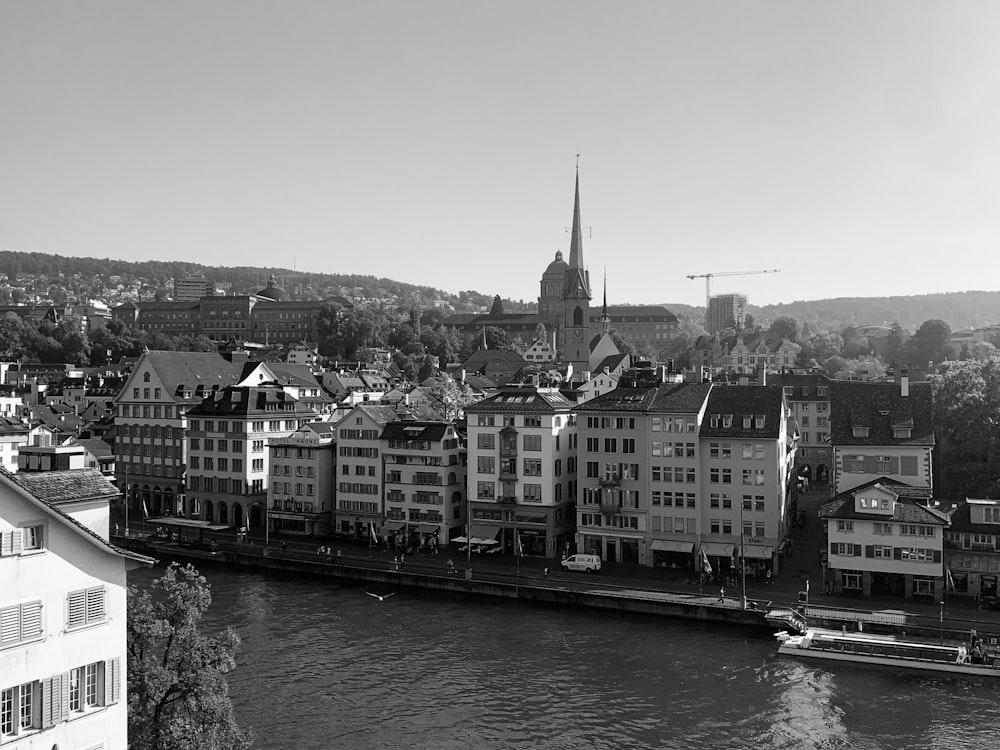 a black and white photo of a river and buildings