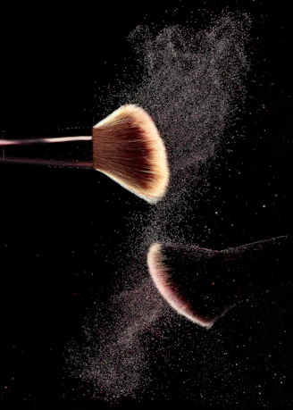 a close up of a makeup brush on a black background