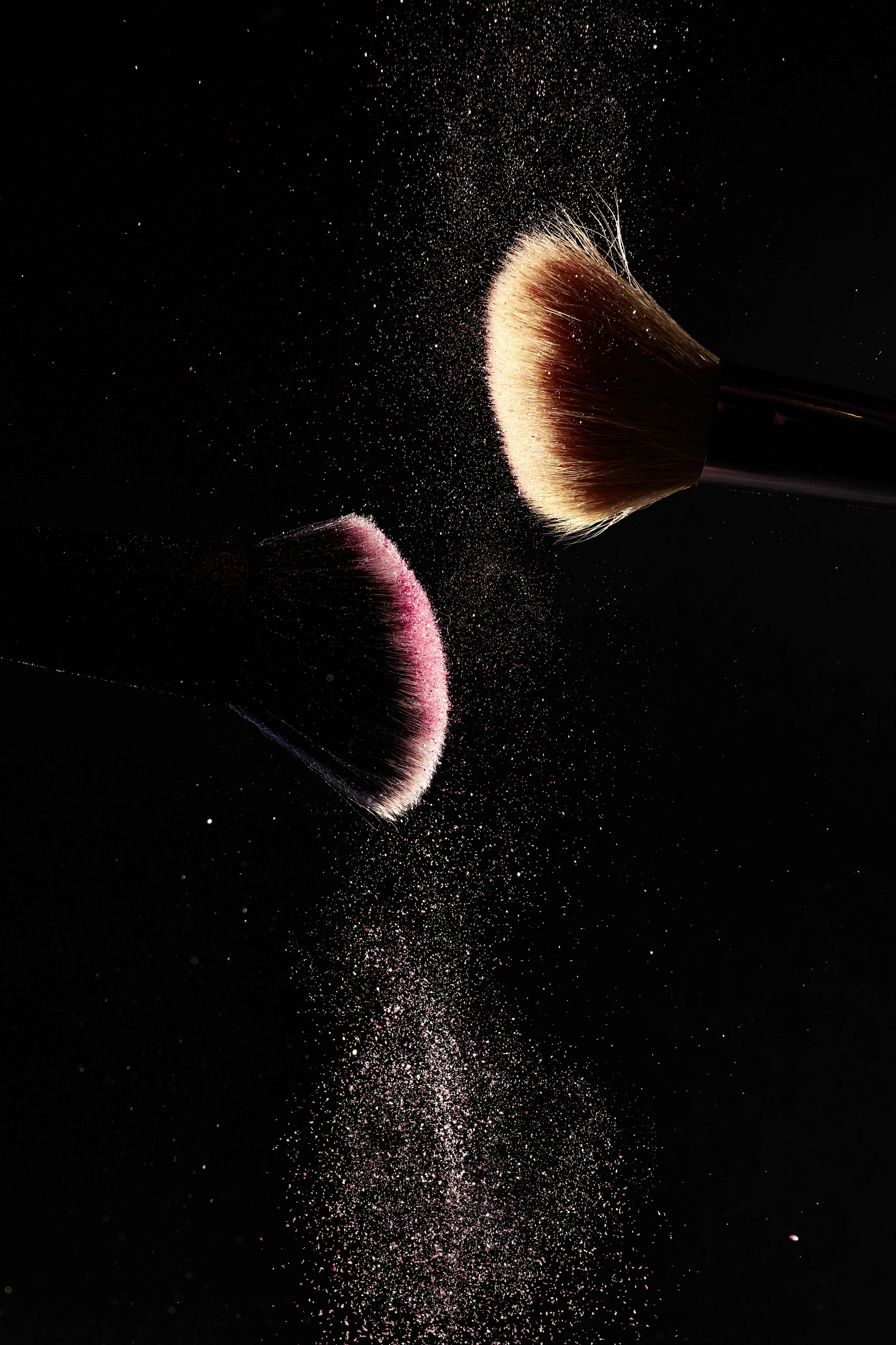 a close up of two makeup brushes on a black background