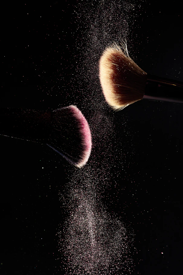 a close up of two makeup brushes on a black background