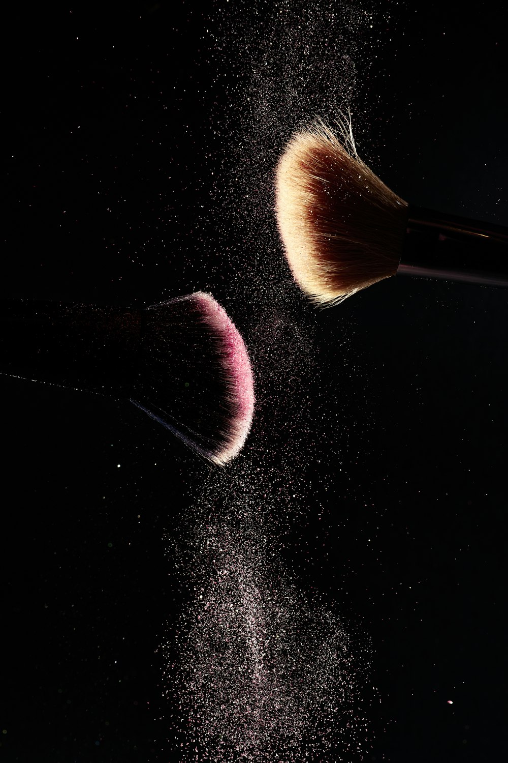a close up of two makeup brushes on a black background
