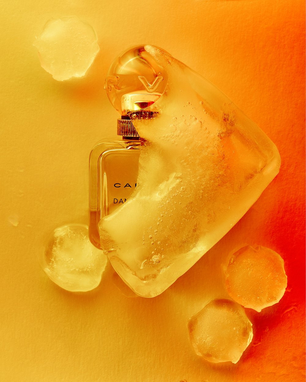 a bottle of perfume sitting on top of ice