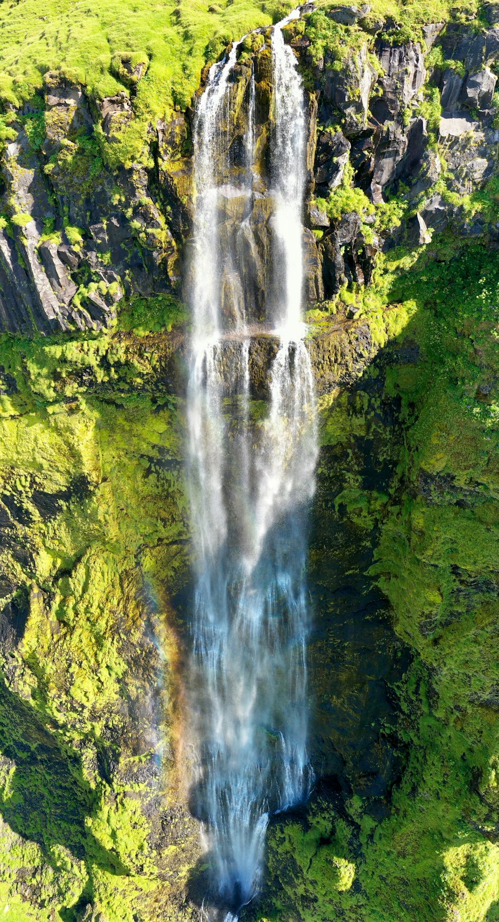 an aerial view of a waterfall in the mountains