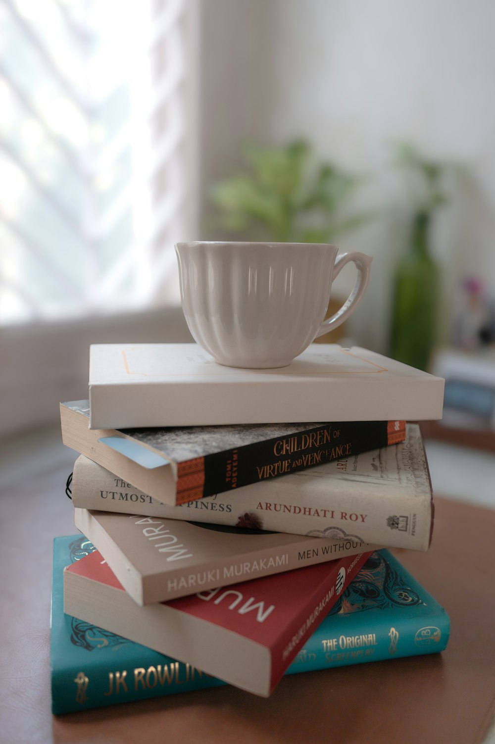 a stack of books and a cup on a table