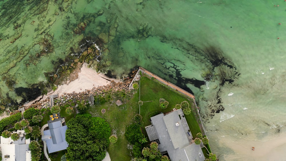 an aerial view of a house next to the ocean