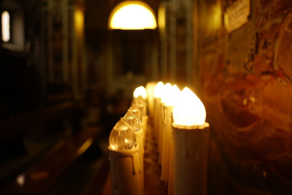 a row of lit candles sitting on top of a table