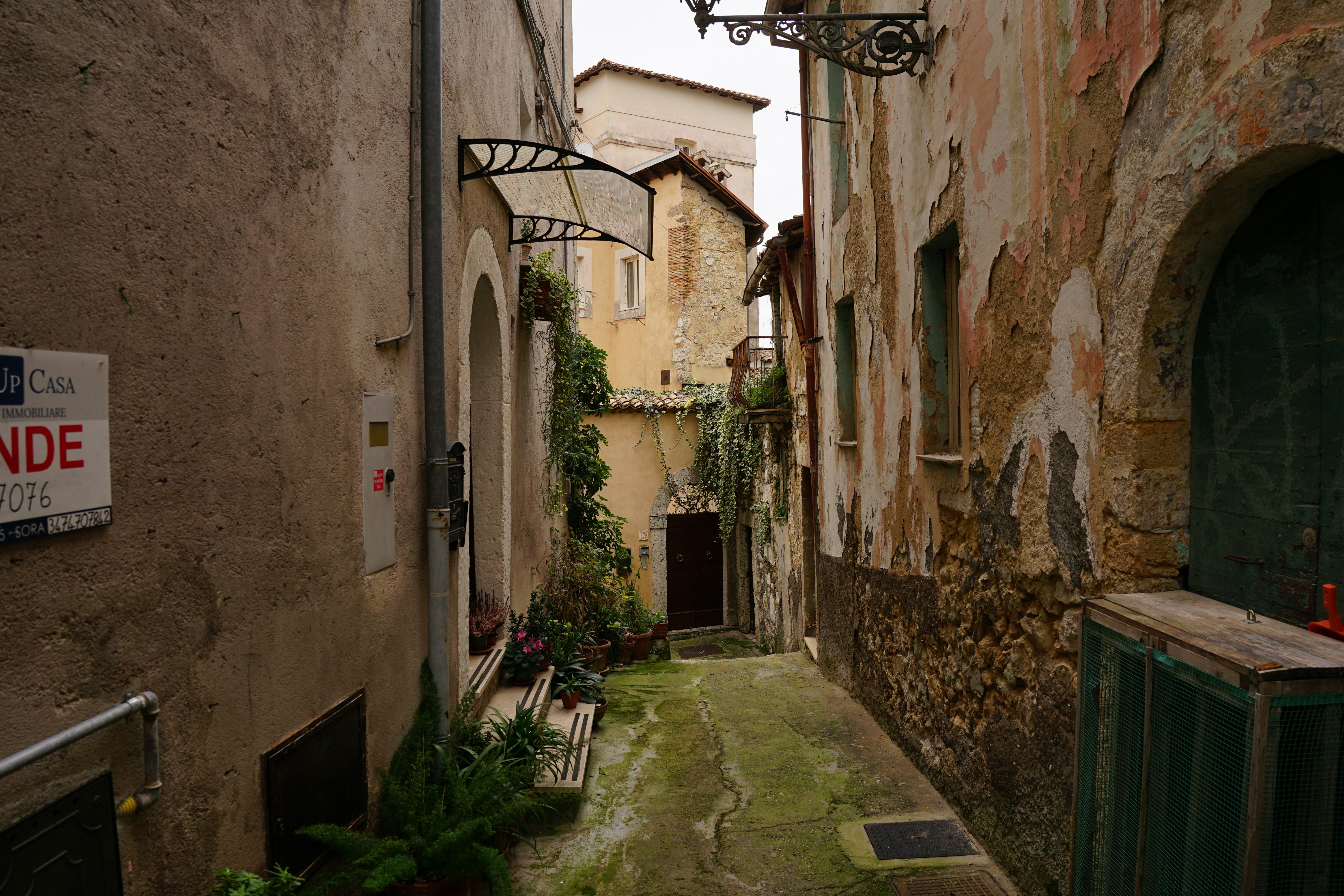 a narrow alley with a bench and a sign, 