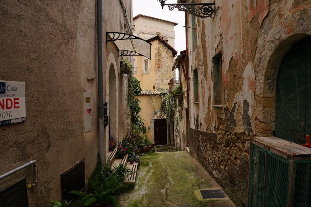 a narrow alley with a bench and a sign