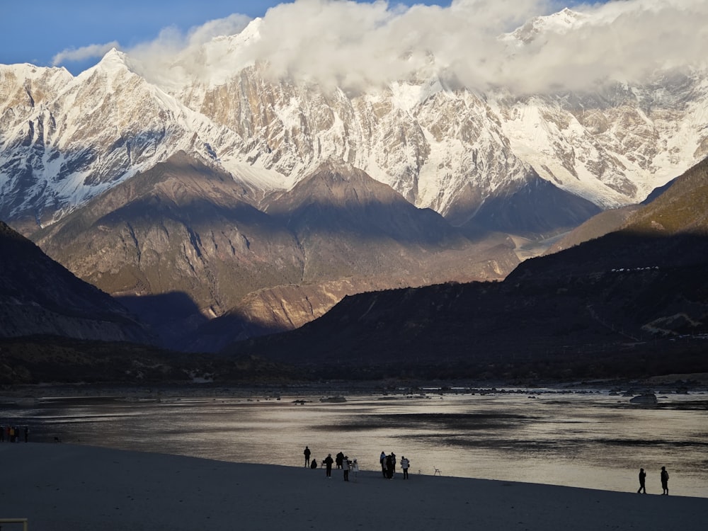 a group of people standing on top of a sandy beach