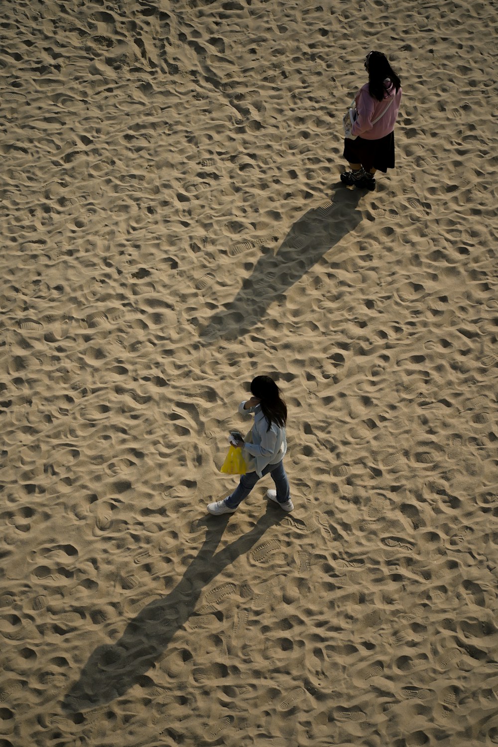 two young girls playing in the sand on a beach