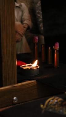 a lit candle sitting on top of a wooden table