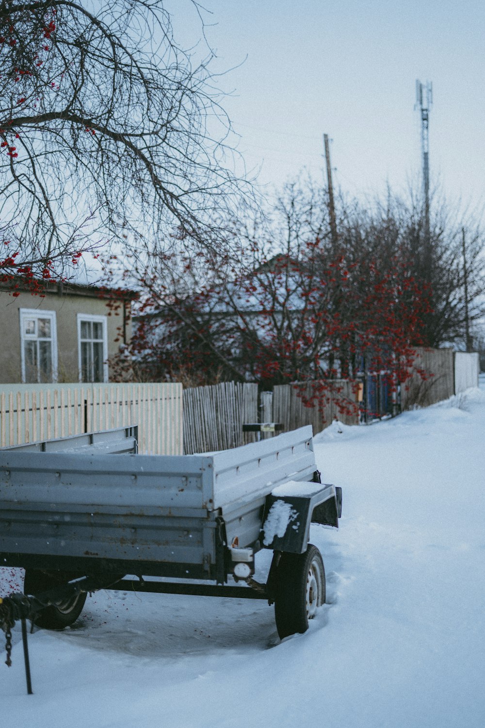 a truck is parked in the snow near a fence