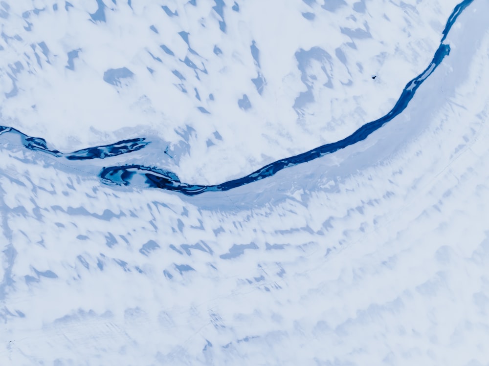 an aerial view of a river in the snow