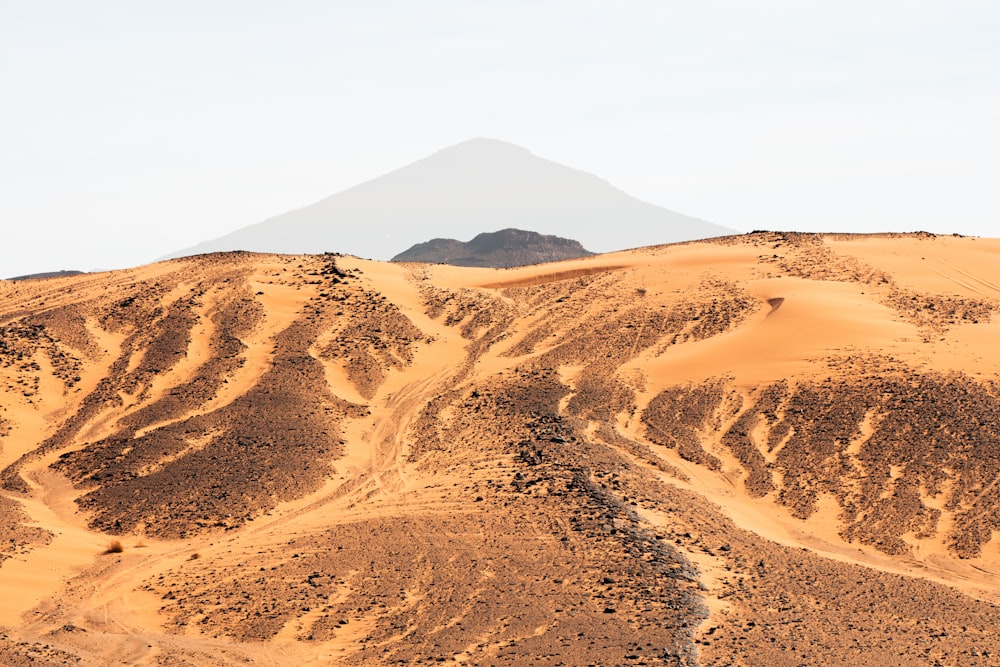 a large mountain with a very tall mountain in the background