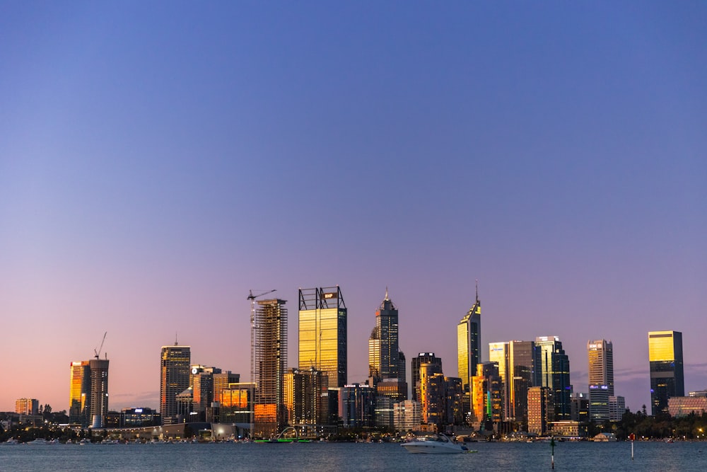 a view of a city at dusk from across the water