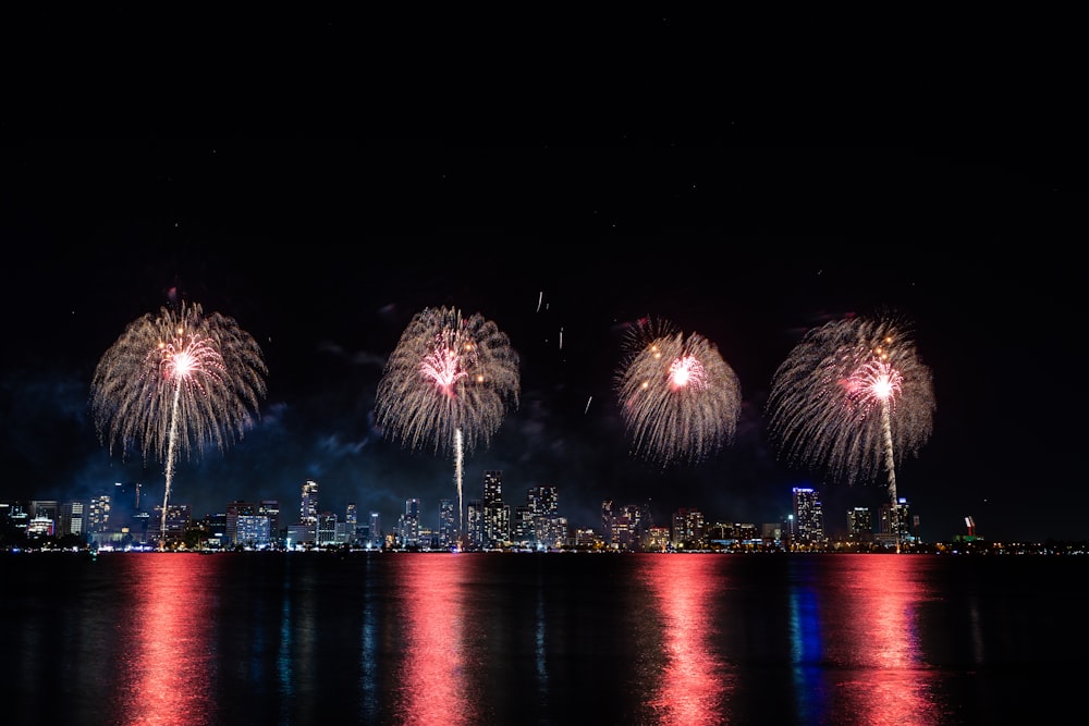 fireworks are lit up in the night sky over a city