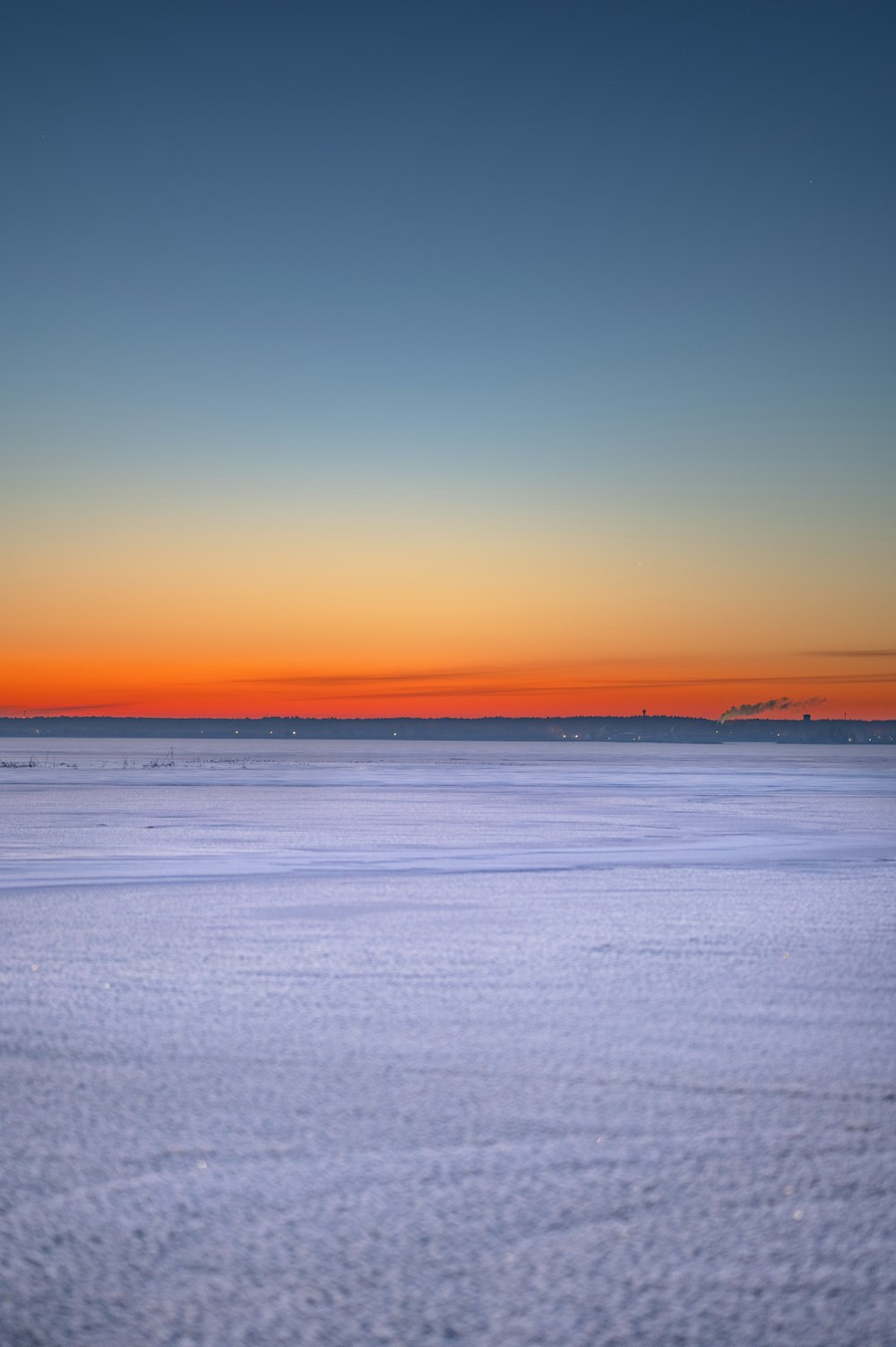 the sun is setting over the horizon of a large body of water