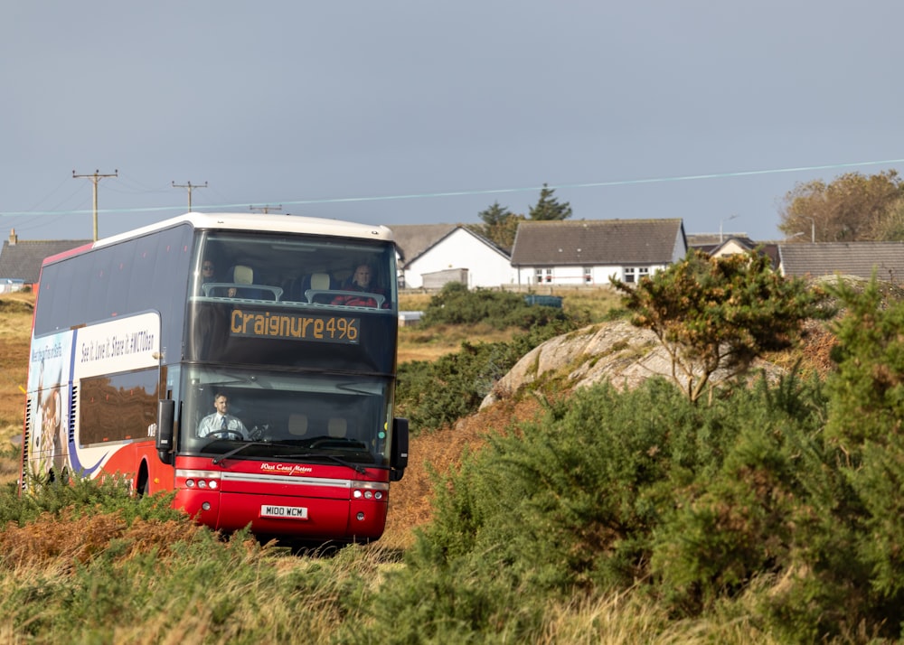 a double decker bus driving down a dirt road