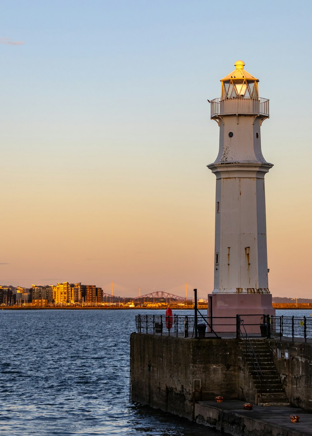 ein Leuchtturm, der auf einem Pier neben dem Meer sitzt