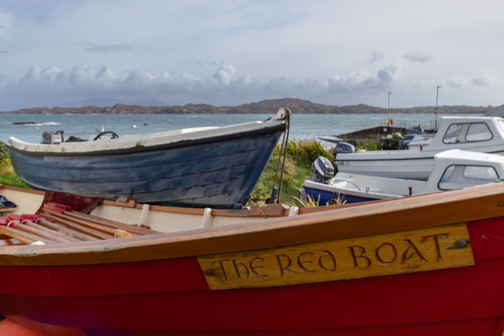 a red boat sitting next to a body of water