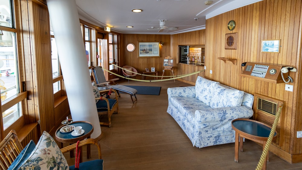 a living room filled with furniture and wooden walls