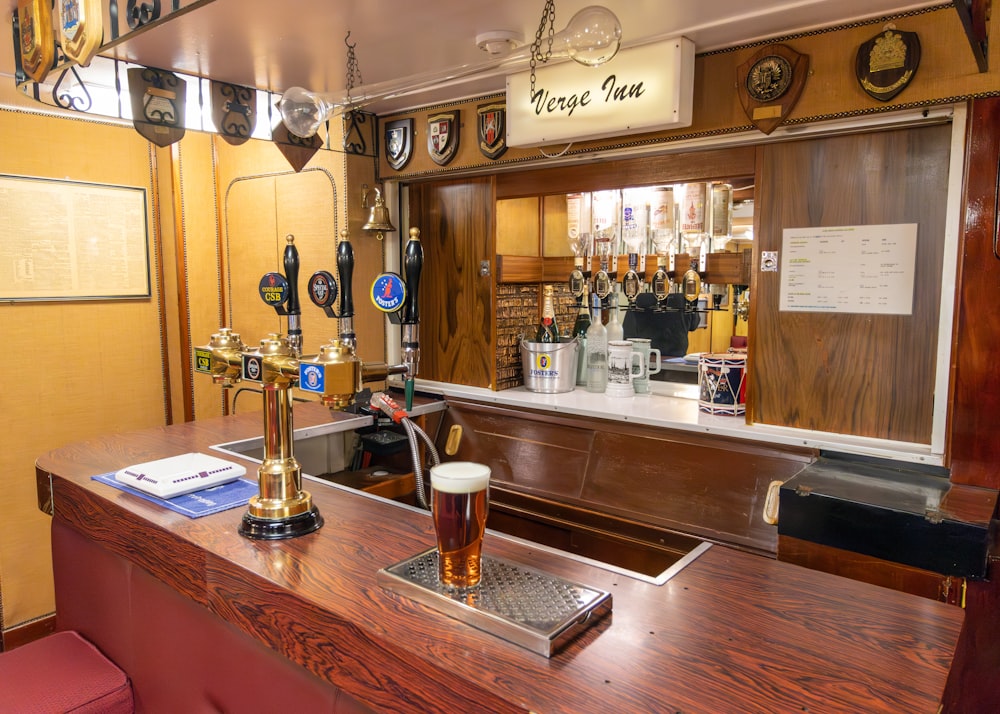 a bar with a wooden counter and a red stool