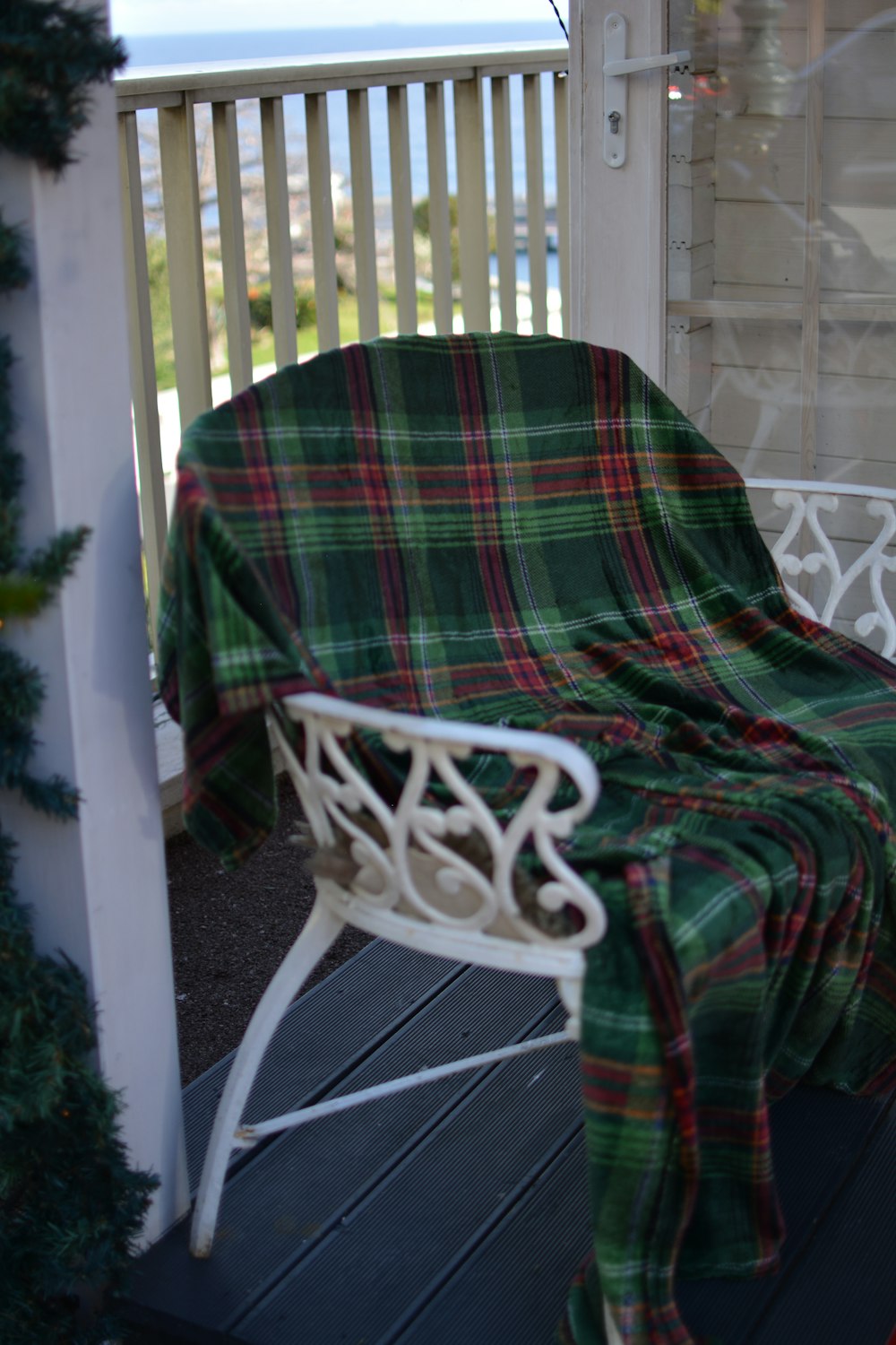 a plaid blanket on a chair on a porch