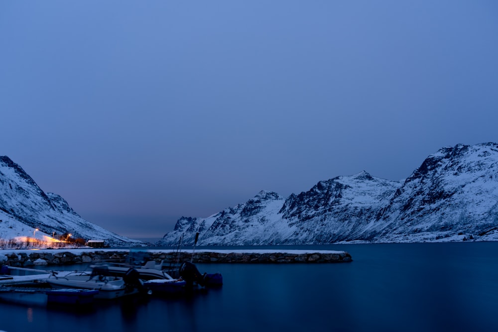 snow covered mountains surrounding a body of water